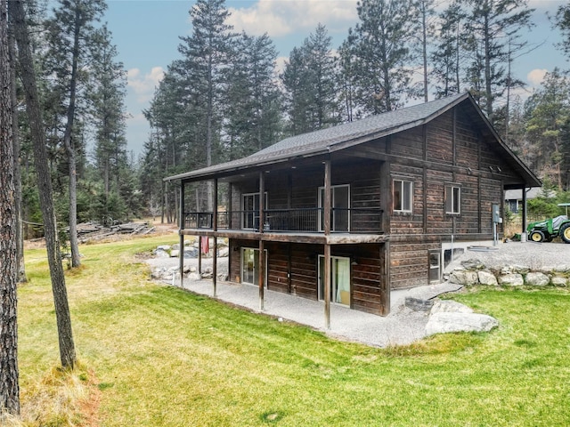 rear view of house featuring a lawn and a deck