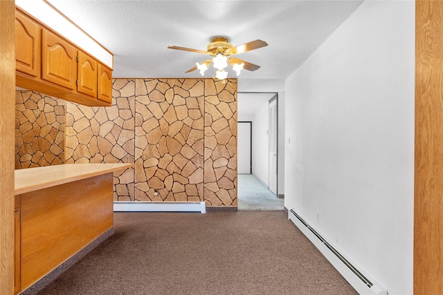 spare room featuring a baseboard heating unit, carpet floors, and ceiling fan