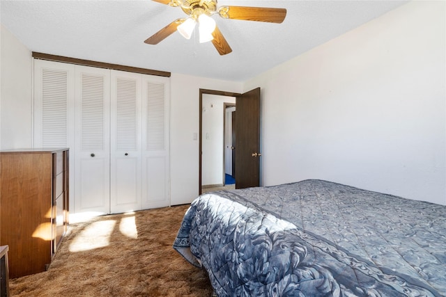 bedroom featuring ceiling fan, a textured ceiling, dark carpet, and a closet