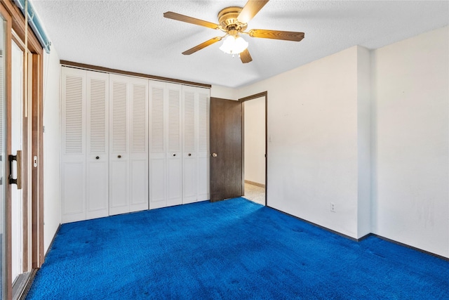 unfurnished bedroom featuring a closet, a ceiling fan, dark colored carpet, and a textured ceiling