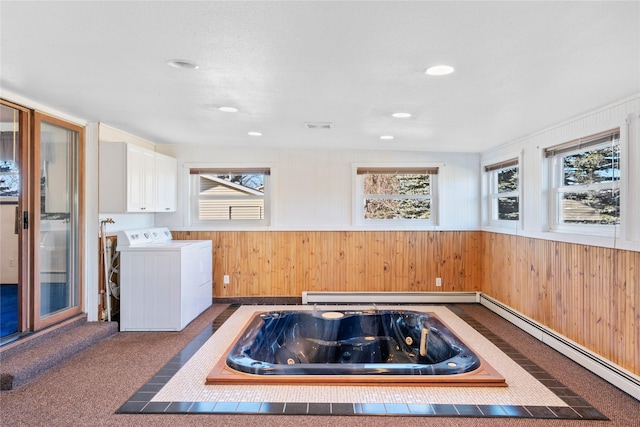 clothes washing area featuring a baseboard radiator, separate washer and dryer, wainscoting, cabinet space, and dark colored carpet