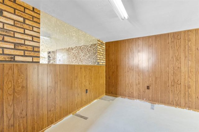 unfurnished room with concrete floors and wood walls