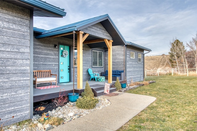 doorway to property featuring a wooden deck and a lawn