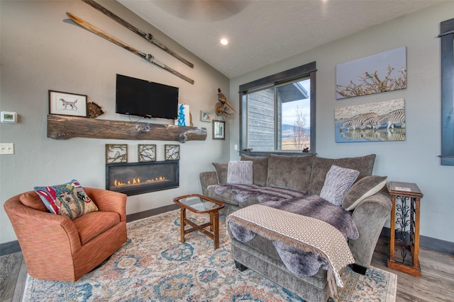 living room with hardwood / wood-style flooring, vaulted ceiling, and a textured ceiling