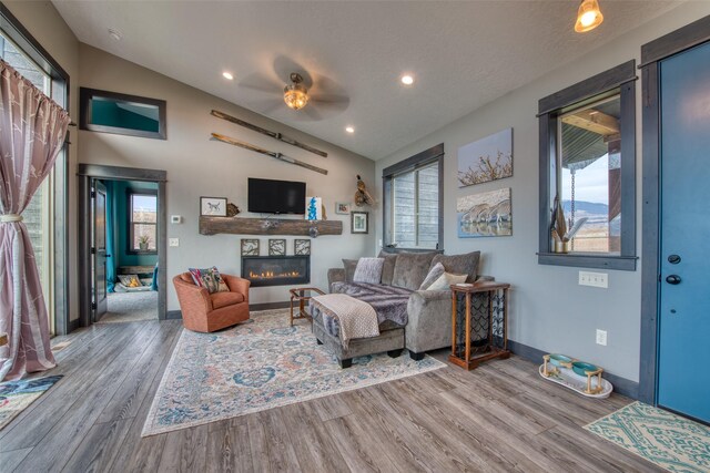 living room with hardwood / wood-style floors, vaulted ceiling, and a textured ceiling