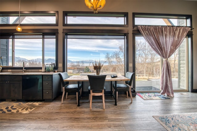 dining area with a mountain view, hardwood / wood-style floors, sink, and a chandelier