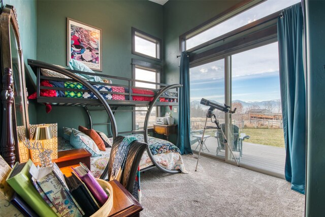 carpeted bedroom featuring access to exterior and a mountain view