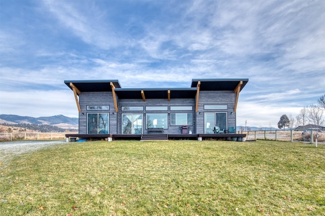 rear view of property featuring a yard and a mountain view