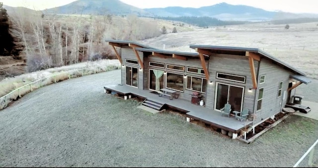 rear view of house featuring a deck with mountain view