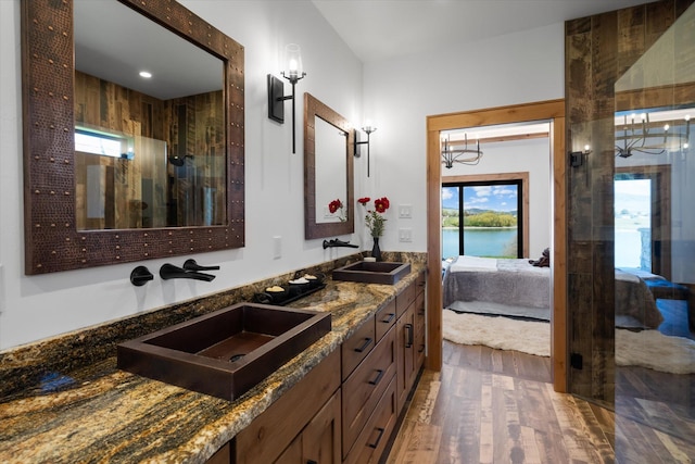 bathroom featuring a water view, wood finished floors, a sink, and ensuite bathroom