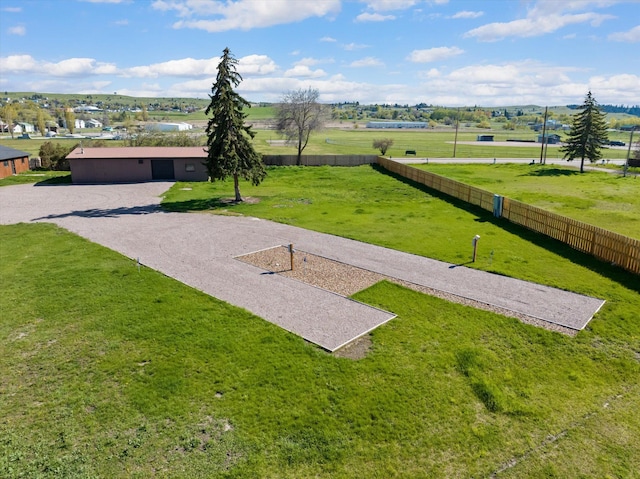 view of community with a yard and fence