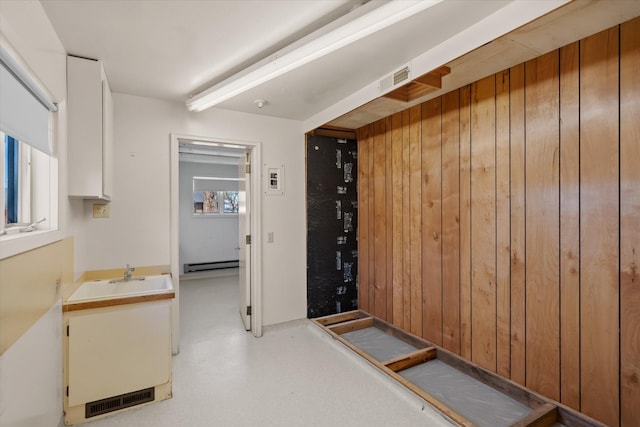 hall with wood walls and baseboard heating