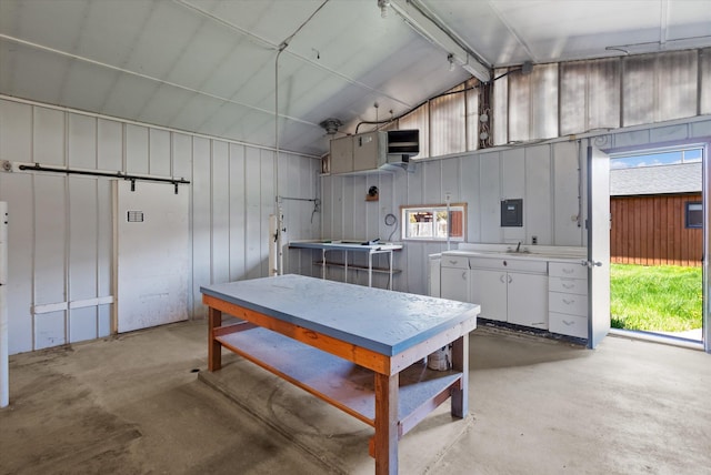 kitchen featuring lofted ceiling, a sink, white cabinets, light countertops, and unfinished concrete flooring