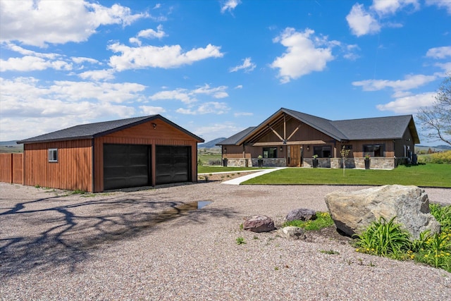 view of front facade with a detached garage and a front lawn