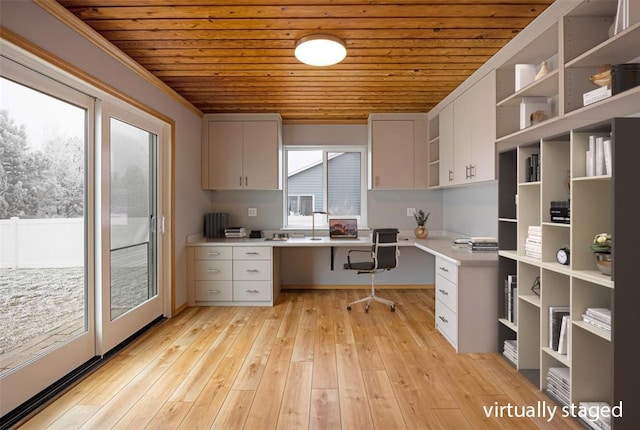 interior space with wooden ceiling, light wood-type flooring, white cabinets, built in desk, and ornamental molding