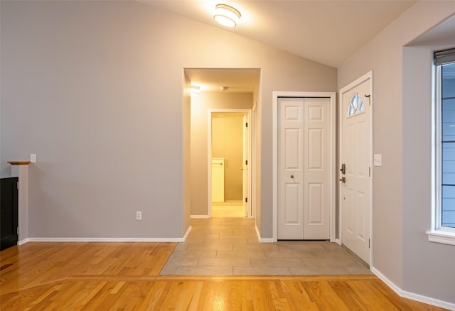 foyer entrance with lofted ceiling and light hardwood / wood-style flooring