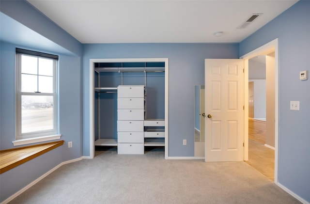 unfurnished bedroom with a closet and light colored carpet