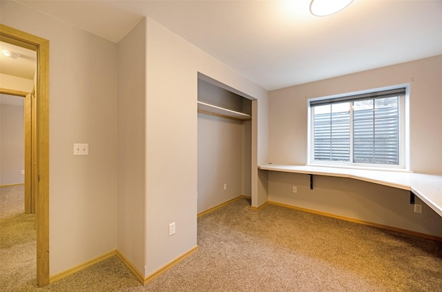 unfurnished bedroom with light colored carpet and a closet