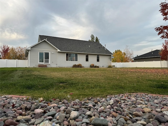 rear view of house featuring a yard