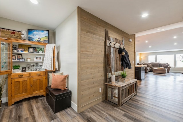 interior space featuring hardwood / wood-style floors, vaulted ceiling, and wood walls