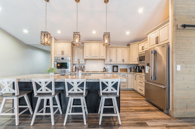 kitchen with decorative light fixtures, a kitchen bar, stainless steel appliances, and wooden walls