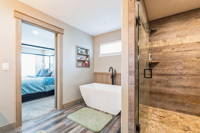 bathroom with shower with separate bathtub and hardwood / wood-style flooring