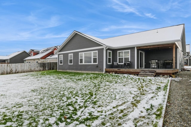 snow covered rear of property featuring a wooden deck