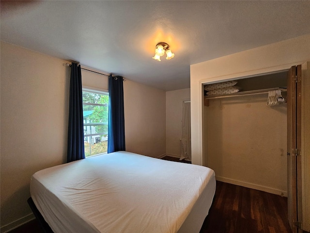 bedroom with dark wood-type flooring and a closet