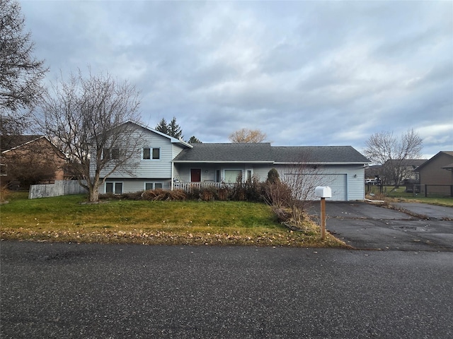 split level home with a garage and a front lawn