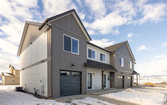 view of front of home with a garage and central air condition unit