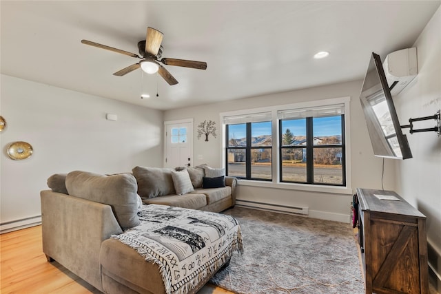 living room featuring hardwood / wood-style floors, ceiling fan, a healthy amount of sunlight, and baseboard heating