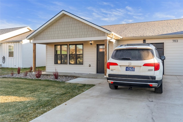 ranch-style home with a garage and a front lawn