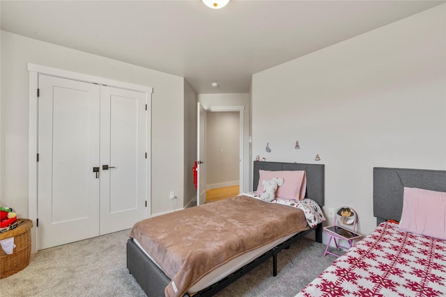 bedroom featuring light colored carpet and a closet