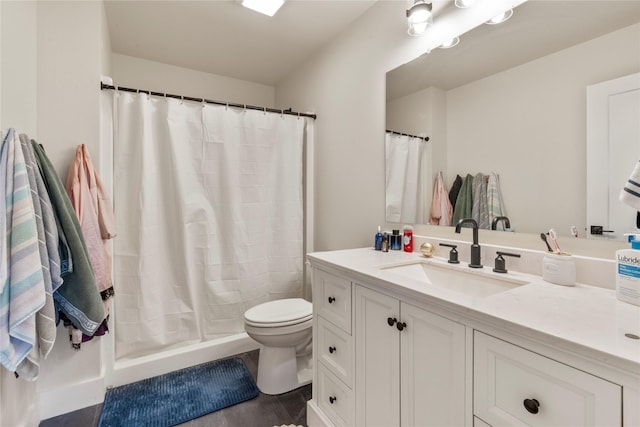 bathroom featuring a shower with shower curtain, vanity, and toilet