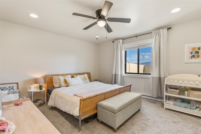 carpeted bedroom featuring ceiling fan and a baseboard heating unit