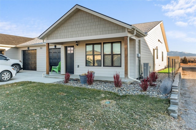 view of front of home with central AC unit, a garage, and a front lawn