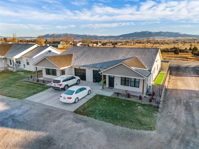 view of front facade featuring a mountain view and a front lawn