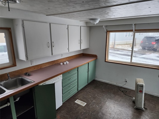 kitchen with visible vents, white cabinetry, a sink, and green cabinetry