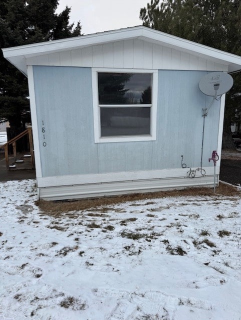 snow covered property featuring an outbuilding