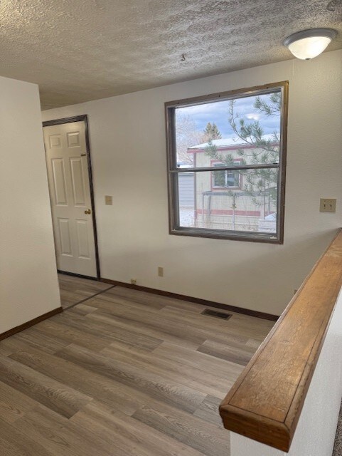 spare room with hardwood / wood-style floors and a textured ceiling