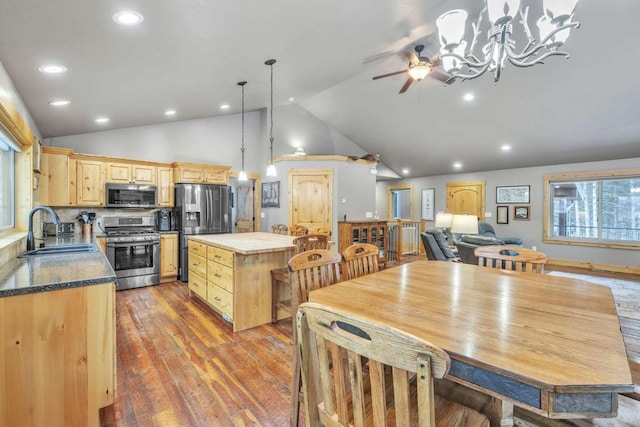 kitchen featuring appliances with stainless steel finishes, sink, a center island, light hardwood / wood-style floors, and hanging light fixtures