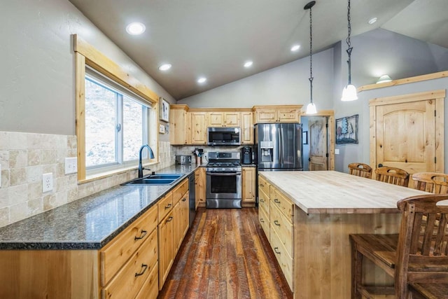 kitchen with decorative backsplash, appliances with stainless steel finishes, dark hardwood / wood-style flooring, sink, and pendant lighting