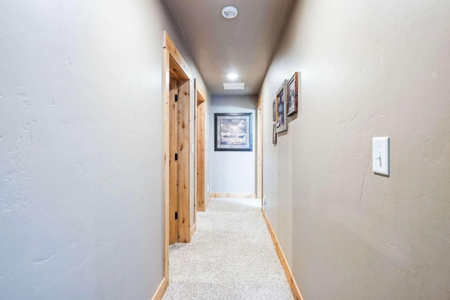 corridor featuring light colored carpet