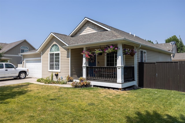 view of front of house with covered porch, a front yard, and a garage