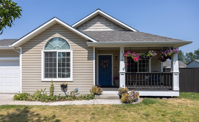 view of front of house with covered porch, a garage, and a front lawn