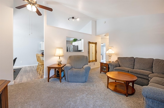 carpeted living room featuring ceiling fan and high vaulted ceiling