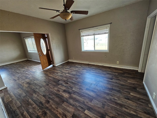 unfurnished bedroom featuring a baseboard radiator, multiple windows, baseboards, and dark wood-style flooring