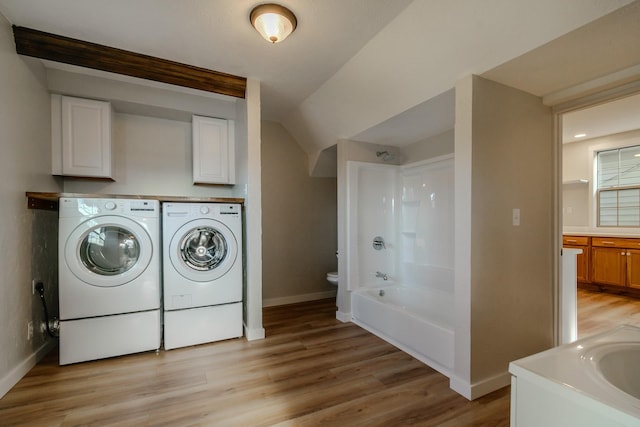 laundry area with light hardwood / wood-style floors and washing machine and clothes dryer