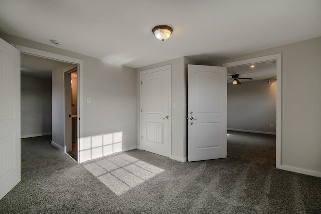 empty room featuring dark carpet and ceiling fan