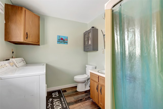 bathroom featuring a shower with shower curtain, independent washer and dryer, toilet, vanity, and hardwood / wood-style flooring